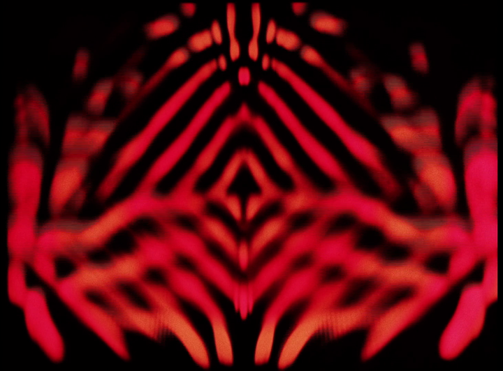 A frame from the early 1970s Doctor Who title sequence. Kaliedoscopic red diamond shape that appears to be made out of flame.